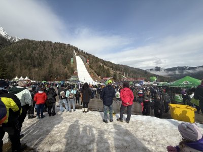 Ko stojim pod velikanko v Planici, me najprej prevzame občutek majhnosti. Letalnica se je neskončna in mogočna. Hkrati me množica okoli mene napolni z energijo. Čuti se, kako vsi dihamo kot eno. Vsak pogled je usmerjen proti vrhu in vsak čaka tisti trenutek tišine pred odrivom in preletom rekordne znamke ter zvoke Avsenikove pesmi. 